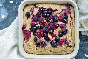 vegan baked oatmeal with berries on top in casserole dish