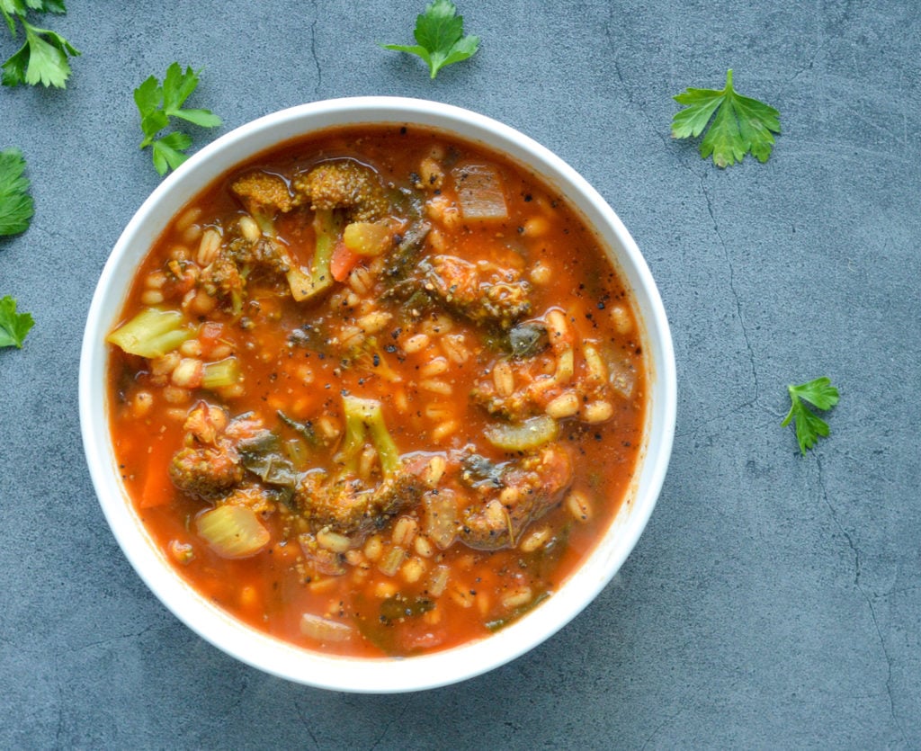 vegetable barley soup against black background